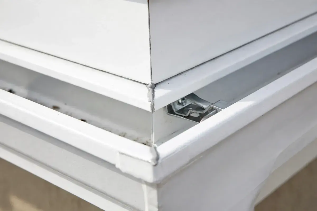 Seamless white aluminum gutter corner with a hidden hanger and a neat sealed joint